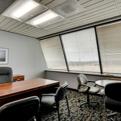 Bright private office featuring a large window and traditional wood desk.