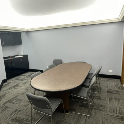 Meeting room with an oval conference table and dark cabinetry.