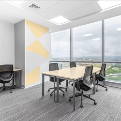Team workspace featuring a light wood table and yellow geometric wall art.