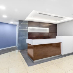 Minimalist reception desk area with a wood and white finish.