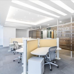 Open-plan workspace with modern desks and a slatted wood partition.