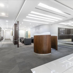 Minimalist office hallway with clean lines and grey carpeting.