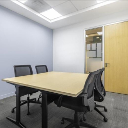 Simple internal meeting room with a light wood table and four chairs.