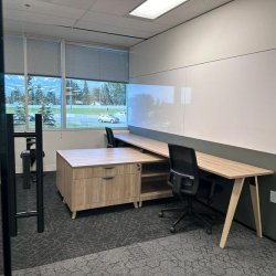 Two-person private office featuring a large whiteboard and floor-to-ceiling window.