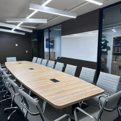 Perspective view of a spacious boardroom with modern seating and linear light fixtures.