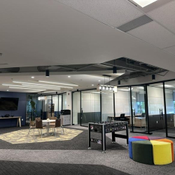 Spacious lounge area featuring a foosball table, colorful seating, and a wall-mounted TV.