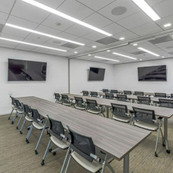 Modern breakroom and kitchen area featuring sleek grey cabinetry and a white marble island.