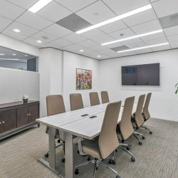 High-rise outdoor balcony with wood-plank flooring and a clear view of the surrounding city towers.
