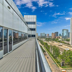 Exterior wide-angle view of the white multi-story office building against a clear blue sky.