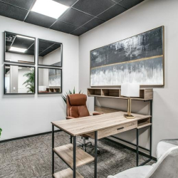 Private office featuring a wooden desk, leather chair, and decorative wall mirrors.