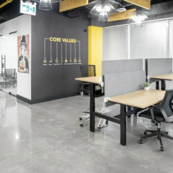 Internal one-person office with floor-to-ceiling glass and minimalist furniture.