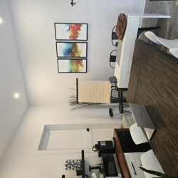 Large wooden conference table in a bright room with colourful wall art.