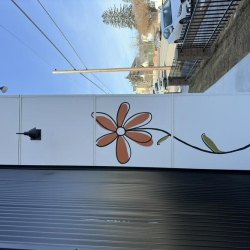 Close-up of a hand-painted orange flower on the building exterior wall.