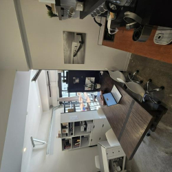 Light-filled office with a long wooden desk and built-in shelving.