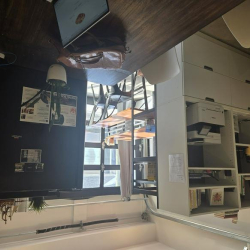 White floor-to-ceiling shelving unit housing a printer and office supplies.