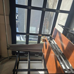 Industrial metal frame structure located near a large window.