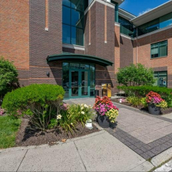Main entrance to the building featuring glass doors and vibrant floral arrangements.
