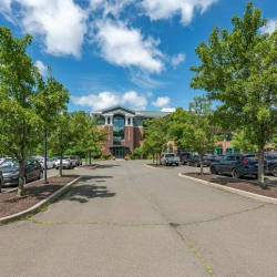Wide view of the building exterior and parking lot under a bright blue sky.