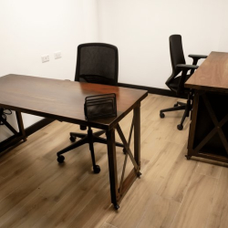 Private office suite with two wooden desks and ergonomic black chairs.