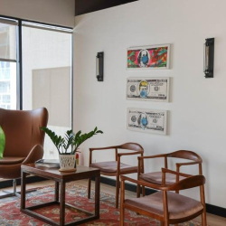 Reception lounge area featuring a tan leather egg chair and decorative wall art.