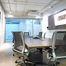 Empty boardroom with high-backed ergonomic chairs and a large table.