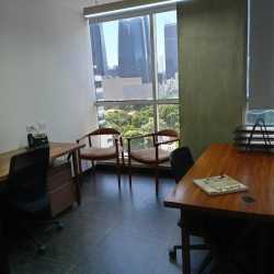 Private office suite with two wooden guest chairs and views of the city skyline.