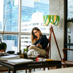 Cozy window-side lounge with a sofa overlooking high-rise buildings.