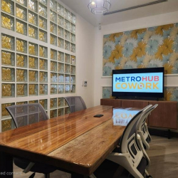 Meeting room with a large wooden conference table and a glass-block feature wall.
