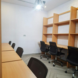 Shared workspace featuring integrated wooden bookshelves and task seating.