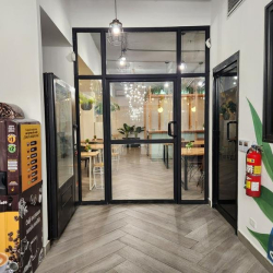 Glass door entrance featuring a coffee vending machine and chevron wood floors.