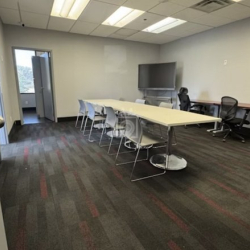 Open plan coworking area with rows of desks and blue chairs, 1903 Central Drive, Bedford, Texas.