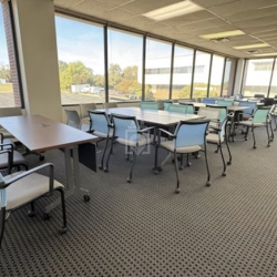 Bright shared office space with multiple desks and window views, 1903 Central Drive, Bedford, Texas.