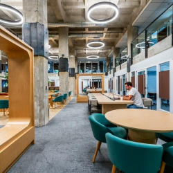 Stylish lounge seating with velvet chairs and round wooden coffee tables.
