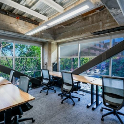 Modern lobby workspace with a wooden booth structure and blue ergonomic chairs.