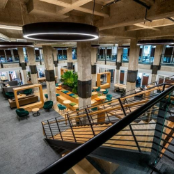 Multi-level atrium with a grand staircase, circular lights, and varied seating.