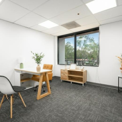 Private office featuring a minimalist white desk and a large window.