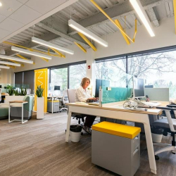 Modern workspace featuring shared desks and yellow storage cabinets.