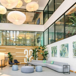 Large multi-level atrium with modern grey seating and spherical light fixtures.