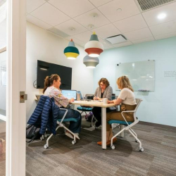 Private meeting room with three people and colorful decorative pendant lights.