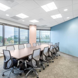 Large conference room featuring a long wooden table and panoramic window views.