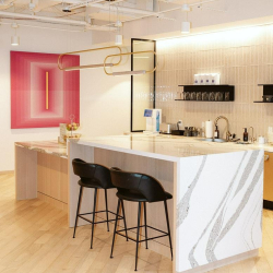 Contemporary office kitchen with a marble-topped island and bar stools.