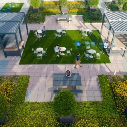 Aerial view of an expansive rooftop terrace with green hedges and seating.