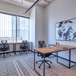 Private office suite with three desks and floor-to-ceiling windows.