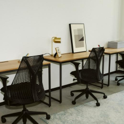 Row of workstations in a bright, open-plan office setting.