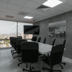 Bright boardroom with a large conference table and panoramic city views.