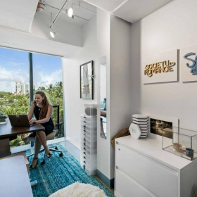 A private office with a blue rug and window view at Axis Space, 333 Las Olas Way, Fort Lauderdale.. Click for details.
