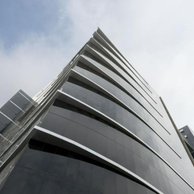 Modern glass skyscraper exterior facade at Avenida Manuel Olguín 327, Lima, Peru.. Click for details.