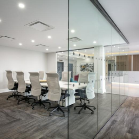 Glass-walled conference room with a large white table and white chairs at 500 – 224 West Esplanade.. Click for details.