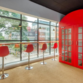 Lounge area with red bar stools and a red phone booth at Financial Park Tower.. Click for details.