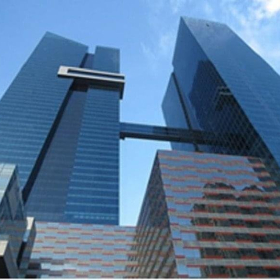Low-angle exterior view of the glass-facade Oceania Business Plaza, Tower 2000 under a clear blue sky.. Click for details.